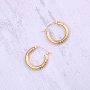 Detail view of thick golden stainless steel hoop earrings with secure latch back closures
