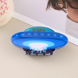 Macro detail of UFO hair claw clip with green aliens on glossy blue acetate