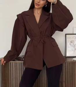 Detail eines dunkelbraunen Blazers mit Puffärmeln und passendem Gürtel in der Taille