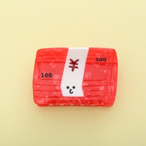 Red cartoon money bag hair claw clip with yuan symbol and 100 print on yellow background