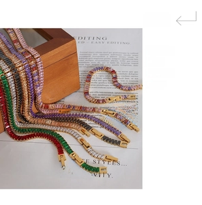 Close-up of gold tennis bracelets with multi-colored rectangular zircon stones and clasps