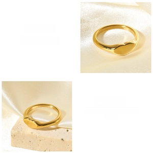 Detail of 18K gold plated heart signet ring on silk background with soft lighting