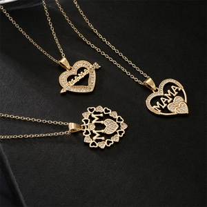 Three 18K gold plated MOM heart necklaces with cubic zirconia on black background