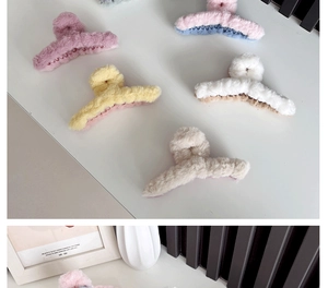Flat lay of colorful plush shark hair claws in pink yellow and white soft tones