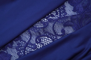Détail macro de la robe bleu foncé montrant la dentelle et la texture du tissu