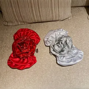 Detail of red and silver rose evening clutch bags with 3D satin petal craftsmanship