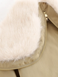 Detailed macro view of khaki parka featuring plush faux fur collar and gold metal zipper