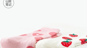 Detail view of pink heart and red strawberry knit patterns on soft mid-calf cotton socks