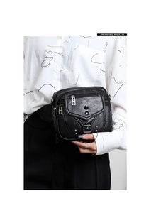 Détail d'un sac bandoulière noir en cuir PU pour femme avec plusieurs compartiments zippés