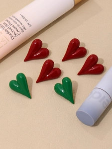 Macro detail of red and green enamel heart stud earrings in stainless steel with PVD plating