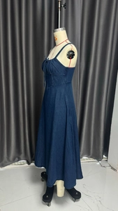 Detailed side view of dark blue denim dress with lace-up waist on mannequin