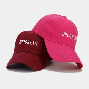 Detail of Brooklyn embroidery on cotton baseball caps in burgundy and rose pink colors