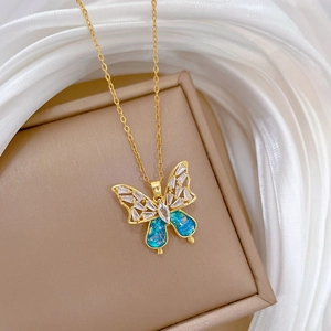 Macro detail of gold butterfly necklace with blue inlay and sparkling white crystals
