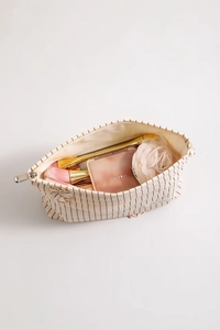 Dettaglio della capiente trousse a righe in tela con scomparti per pennelli da trucco