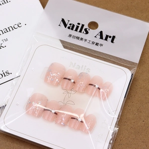 Handmade soft pink press-on nails with glitter gradient and rhinestone accents in packaging