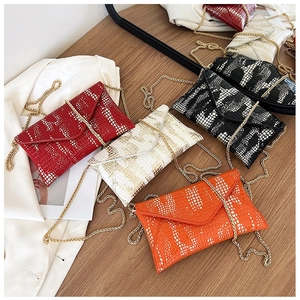 Flat lay of colorful crocodile pattern envelope chain bags in red, white, black and orange