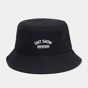Detailed view of white SHITSHOW SUPERVISOR embroidery on a black cotton bucket hat