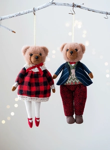 Detail of plush teddy bear charms in checkered outfits hanging on a white branch