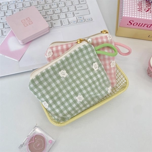 Detail of embroidered floral cosmetic bags with pearl zipper and wrist strap