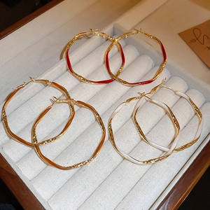 Three pairs of vintage irregular geometric enamel hoop earrings in red, orange, and white