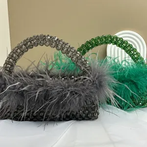 Close-up of handmade beaded handbags in grey and green with ostrich feather trim