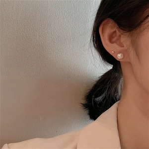 Baroque freshwater pearl and small gold bead stud earrings set shown on a model