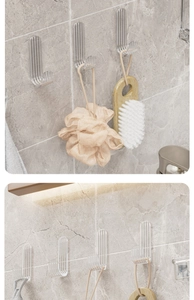 Strong transparent adhesive hooks on marble wall holding bath sponge and wooden brush