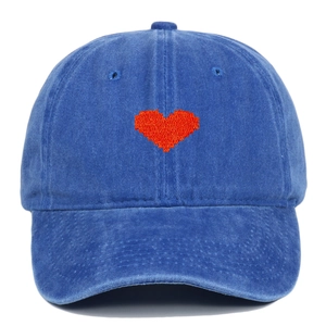 Close-up of red heart embroidery on washed blue denim cotton baseball cap with curved brim