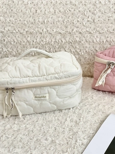 Quilted cloud texture cosmetic bag with ribbon zipper pull in soft white and pink