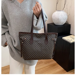 Detailed view of women's tote bag with geometric print and slim brown handles