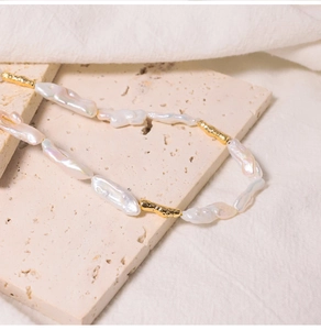 Detailed macro of baroque freshwater pearls and textured gold metal chain links