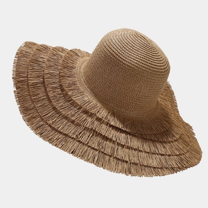 Macro detail of natural straw weaving and four-layer fringed edges on wide-brim beach hat