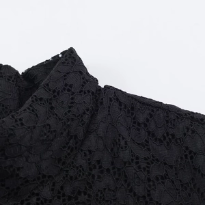 Close-up of intricate black lace fabric texture and neckline detail for women's dress