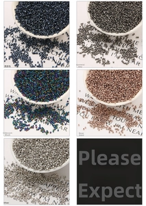 Detailed macro view of 2mm glass seed beads in metallic and iridescent finishes for DIY jewelry