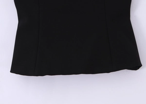 Macro shot of the hem stitching and fine fabric texture on the black bow tube top