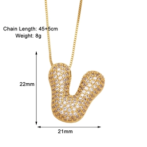 Detail view of gold U-shaped initial necklace with cubic zirconia and dimension labels