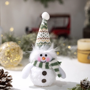 Close-up of plush snowman featuring a green knit hat and striped scarf with festive decor