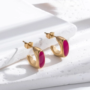 Boucles d'oreilles vintage en C dorées avec émail rose sur un socle en pierre blanc