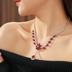 Close-up of vintage flower necklace with red zircon teardrop pendant on model neck