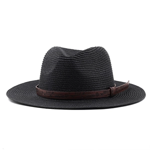 Close-up of black straw sun hat with embossed floral pattern on brown leather band