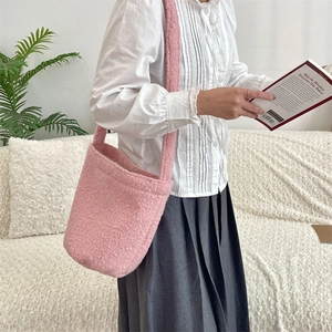 Détail du sac seau rose en peluche avec une large bandoulière en fausse fourrure douce