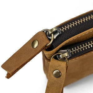 Detail shot of high-quality brown leather texture and durable metal zipper pulls