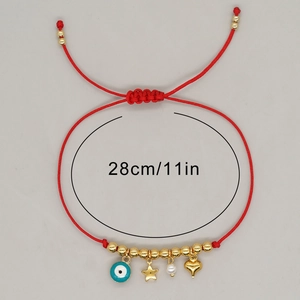Detail of red friendship bracelet with evil eye charm and golden star on gray background