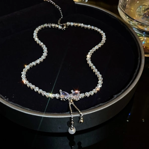 Close-up of sparkling silver rhinestone bow necklace with elegant pearl fringe details