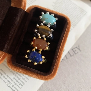 Close-up of vintage gold-plated rings with natural stones like turquoise and tiger eye