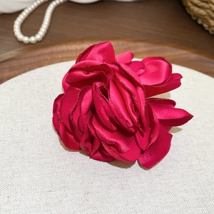 Makroaufnahme eines handgefertigten Seidenblumen-Rings mit schimmernden Blütenblättern