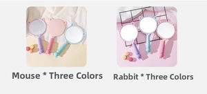 Detail of cute rabbit and mouse shaped handheld makeup mirrors in pink, purple, and blue colors