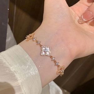 Detailed close-up of rose gold clover bracelet with white mother of pearl and zircon stones