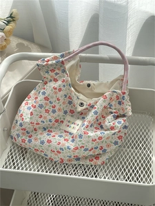 Detail of floral canvas tote bag featuring metal snap button and vintage flower pattern