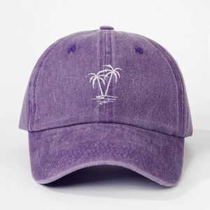 Close-up of white palm tree embroidery on a washed purple cotton baseball cap fabric